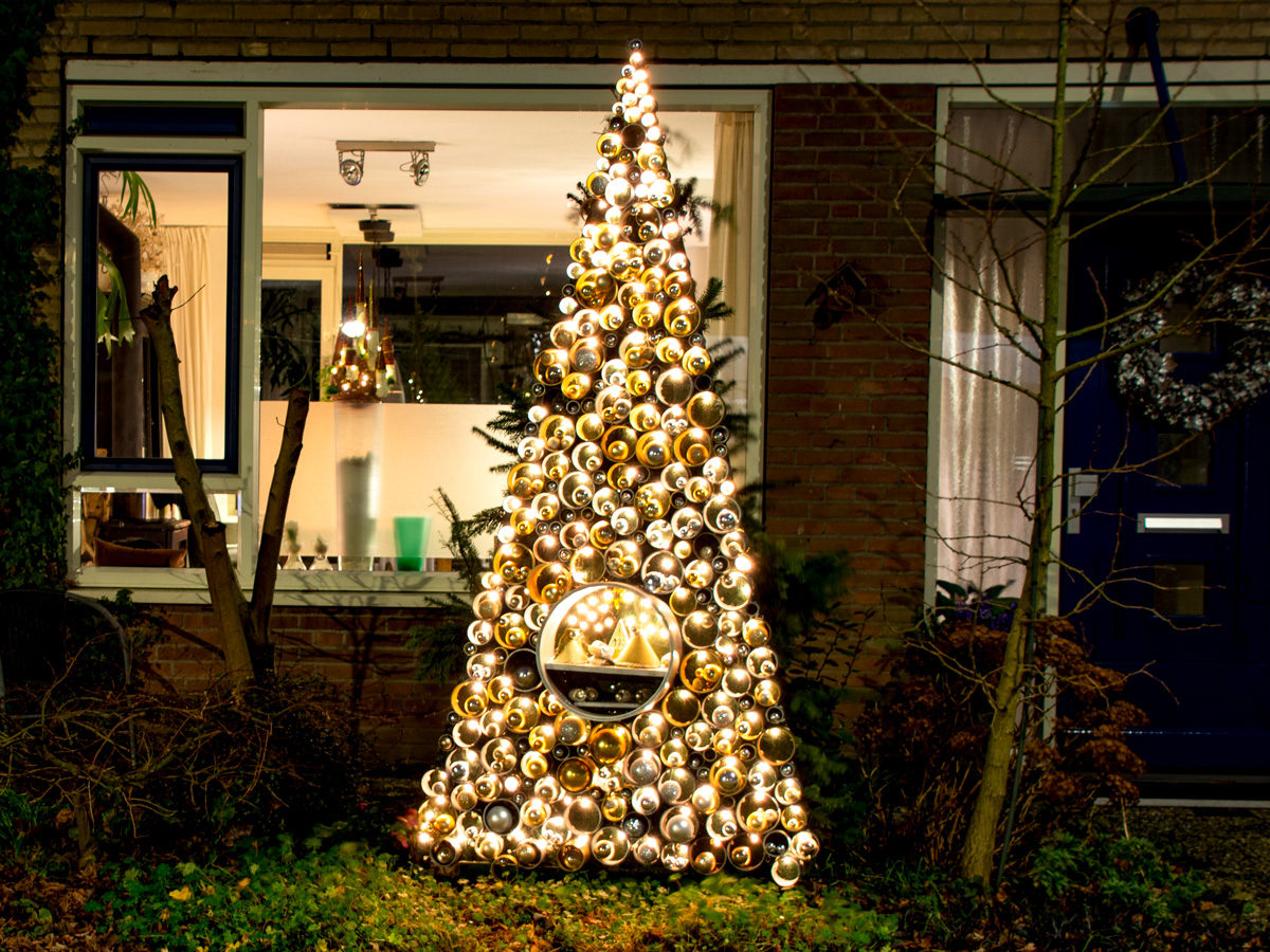 Een verlichte boom voor een huis in het donker