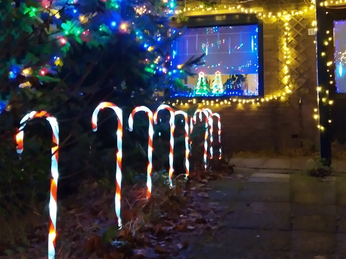 tuinpad in het donker met gekleurde en verlichte snoepstokken