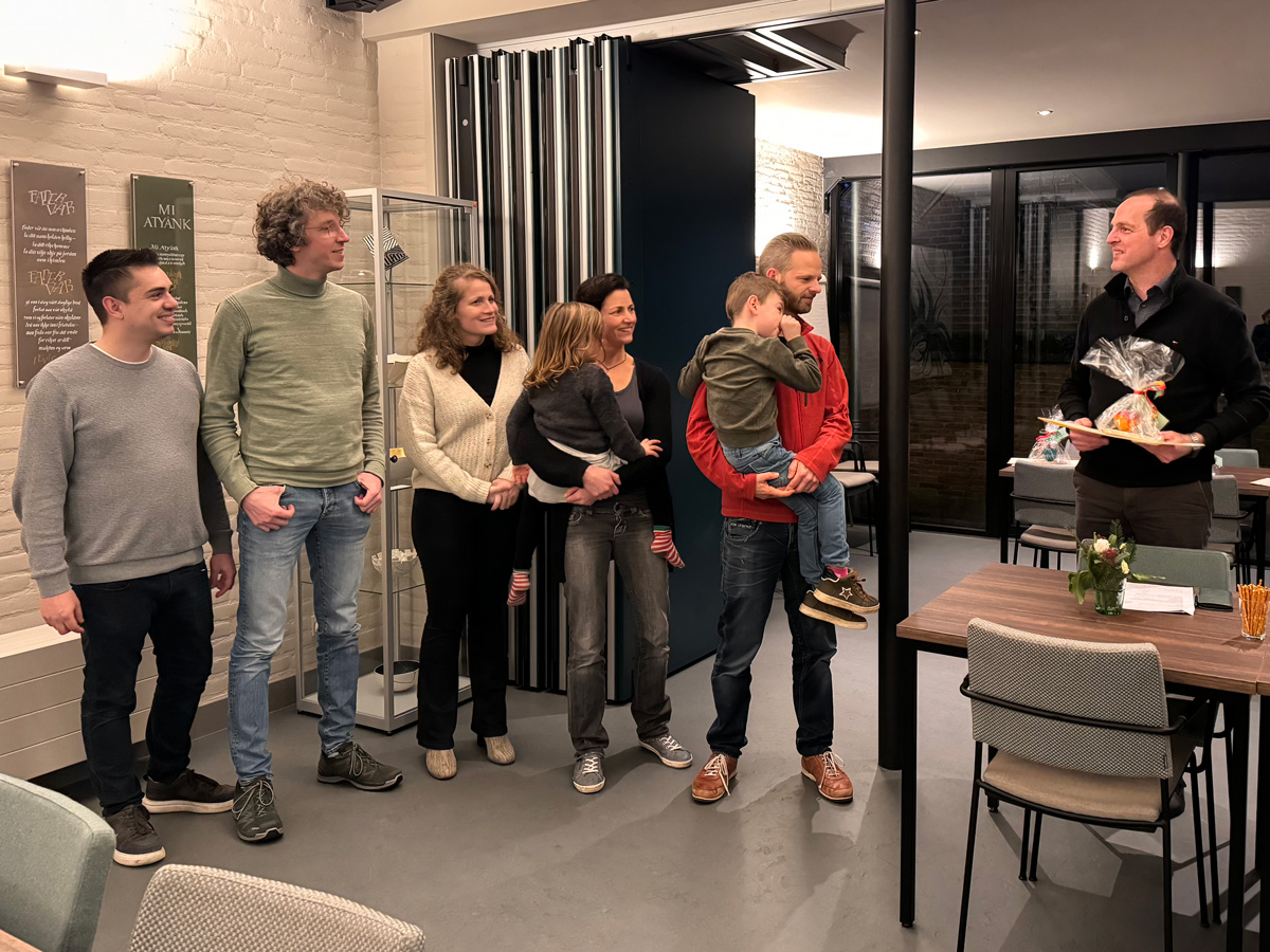 Xander overhandigt eerste prijs aan de groep makers van kerstcreatie Posthoornstraat 20