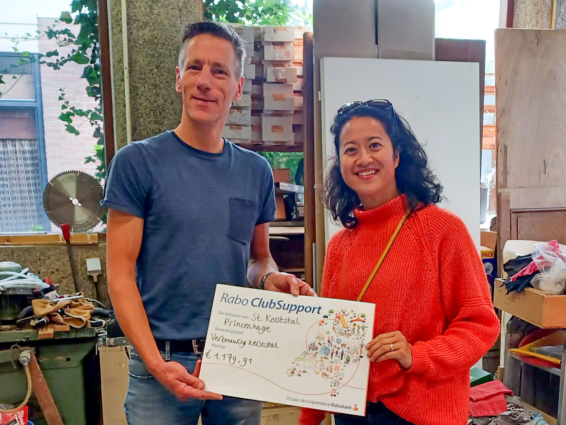 Medewerker van Rabobank overhandigt cheque aan Ruud Craen, de voorzitter van de kerststal