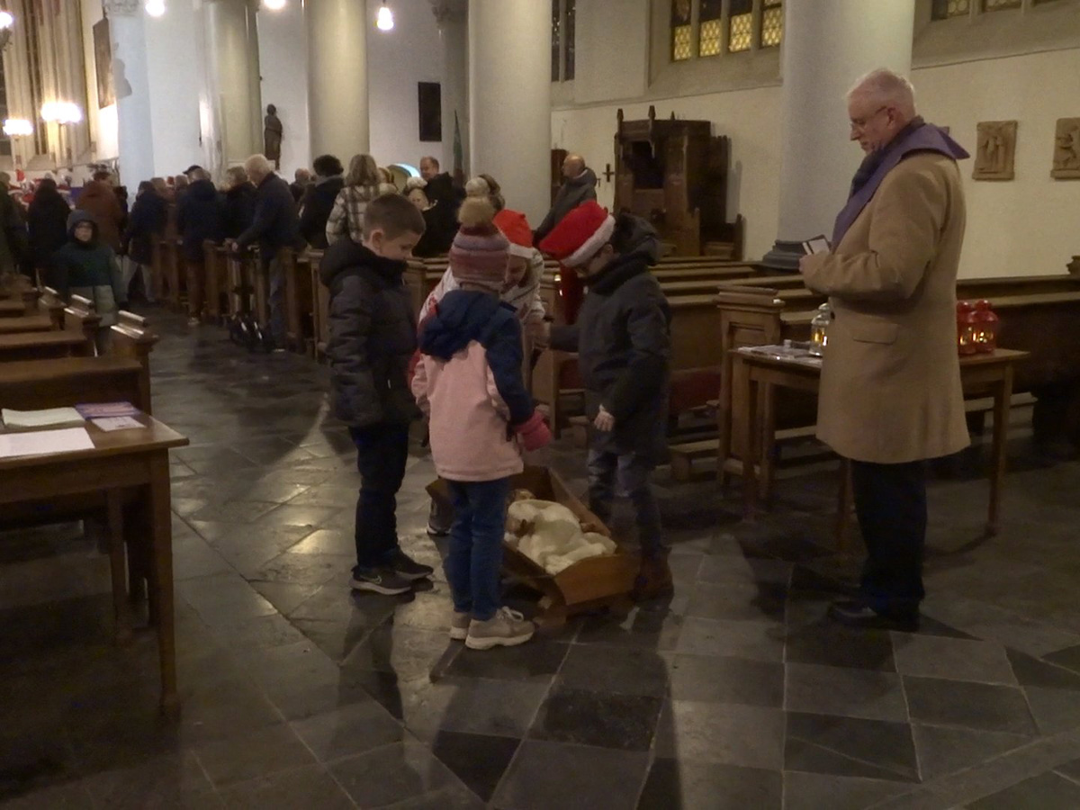 kinderen staan bij de kribbe met kindeke Jezus