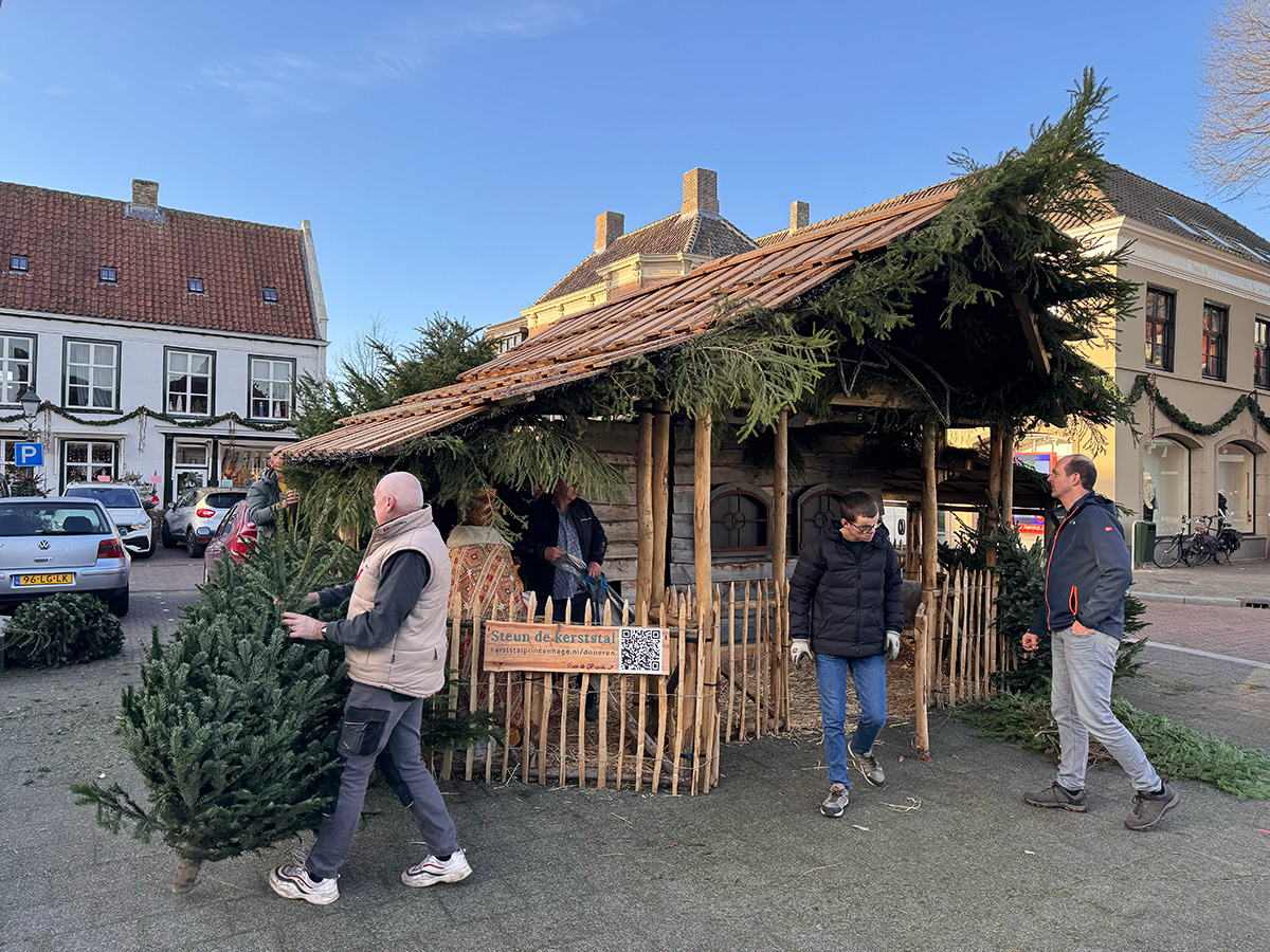 bord 'Steun de kerststtal' bevestigd aan het hek van de kerststal