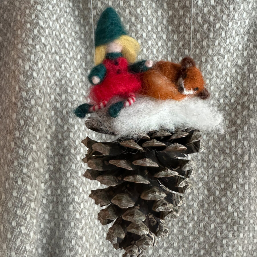 Dennenappel met er  en boven op een kerstelf een rendier gemaakt van vilt