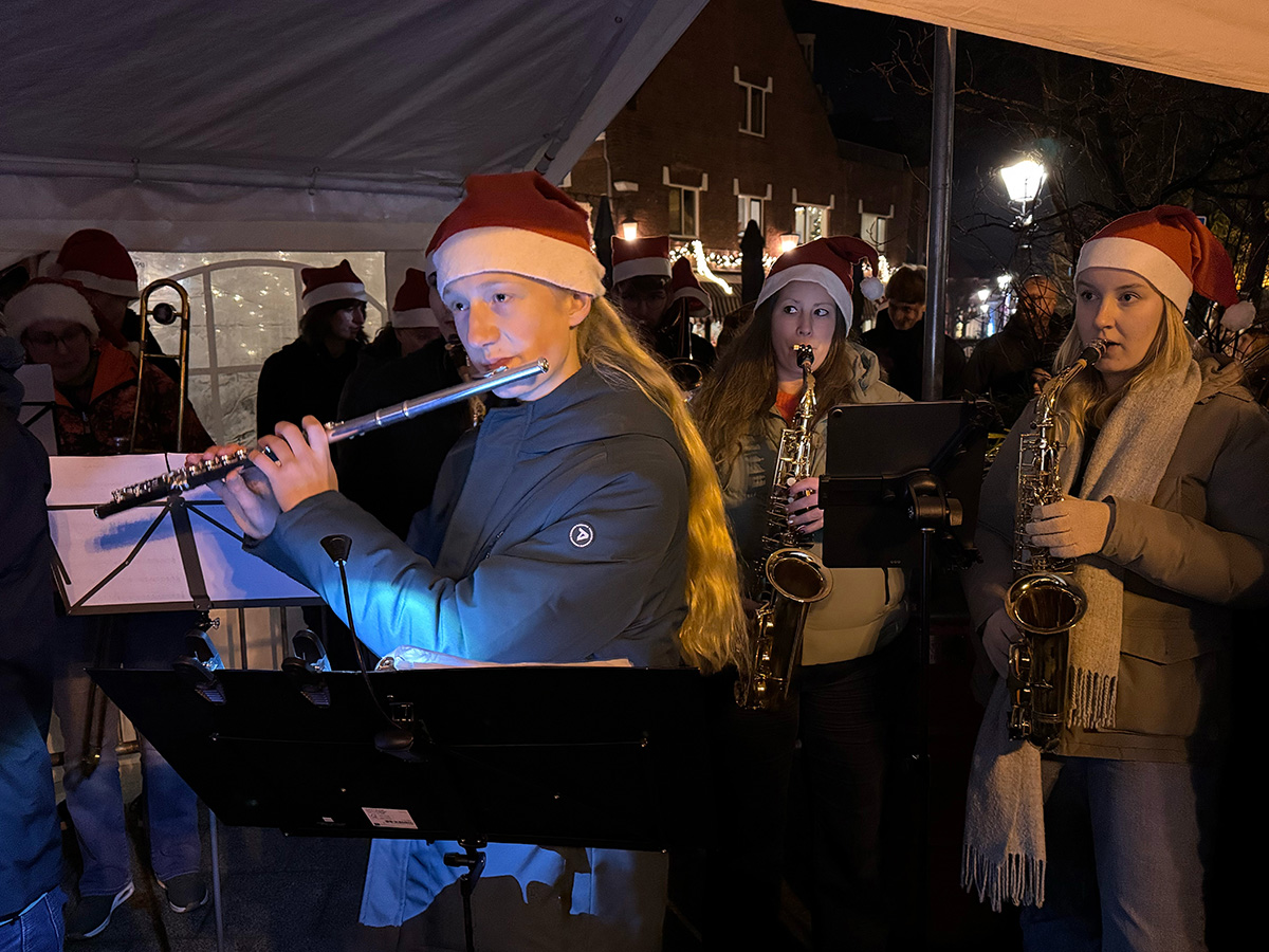 Een dwarsfluitspeler en twee saxofonisten van Harmonie Cecilia spelen muziek bij de opening van de kerststal