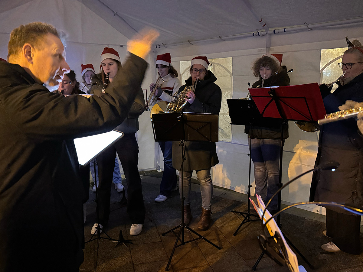 Blazers van harmonie-orkest Cecilia spelen muziek. Dirigent Jurgen van Damen geeft aanwijzingen