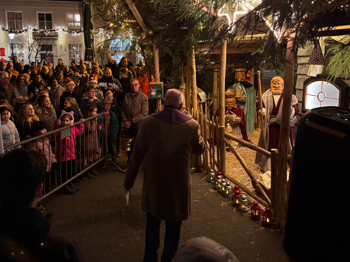 Publiek kijkt naar de verlichte kerststal