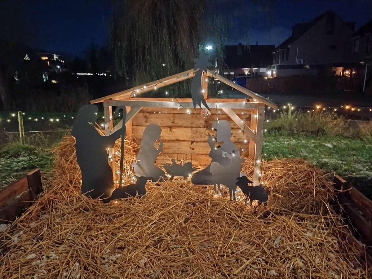 een mini kerststal op een veld van stro