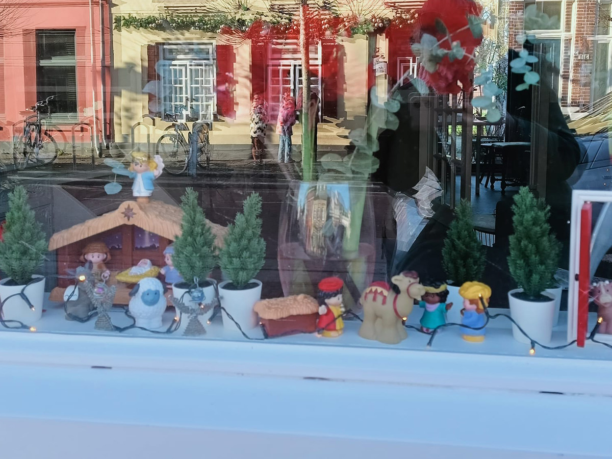 kerststal van ficher price achter een raam
