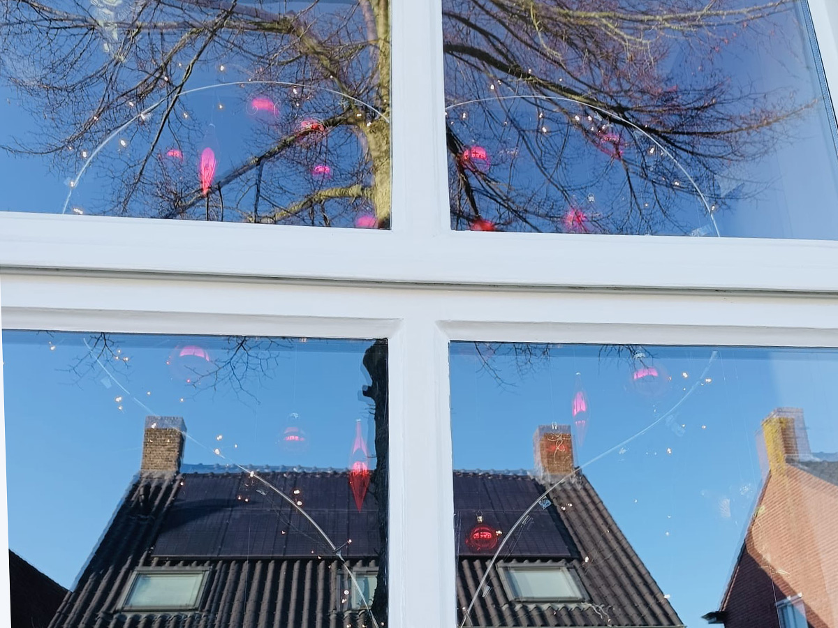 een hart van lichtjes achter een raam