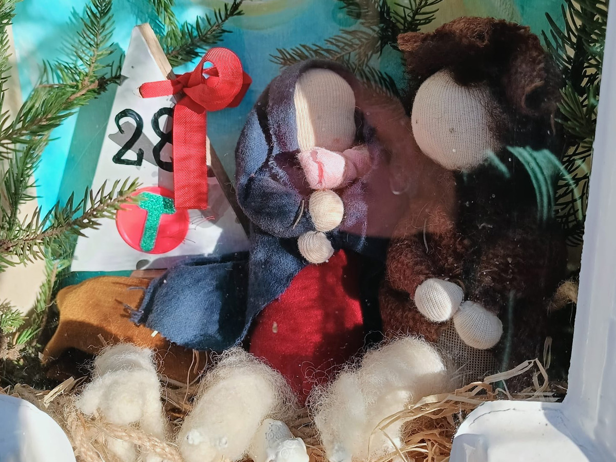 kleine handgemaakte poppetjes achter een raam