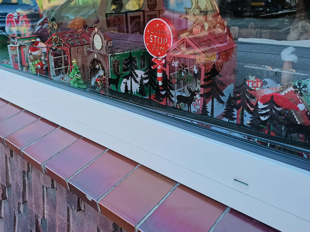 kerstdorp met diverse huisjes achter een raam
