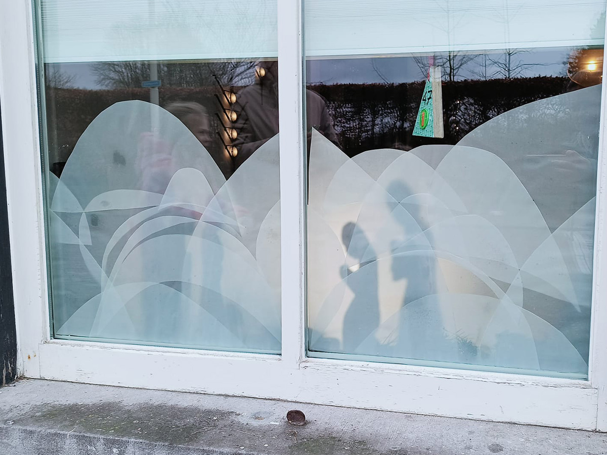 raam beplakt scene uit het kerstverhaal gemaakt met geknipte witte halfdoorzichtige vellen papier.