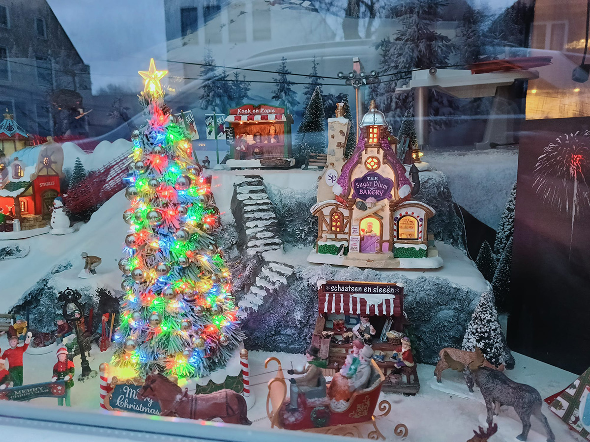 kerstdorp van diverse huisjes met een vrolijk gekleurde kerstboom